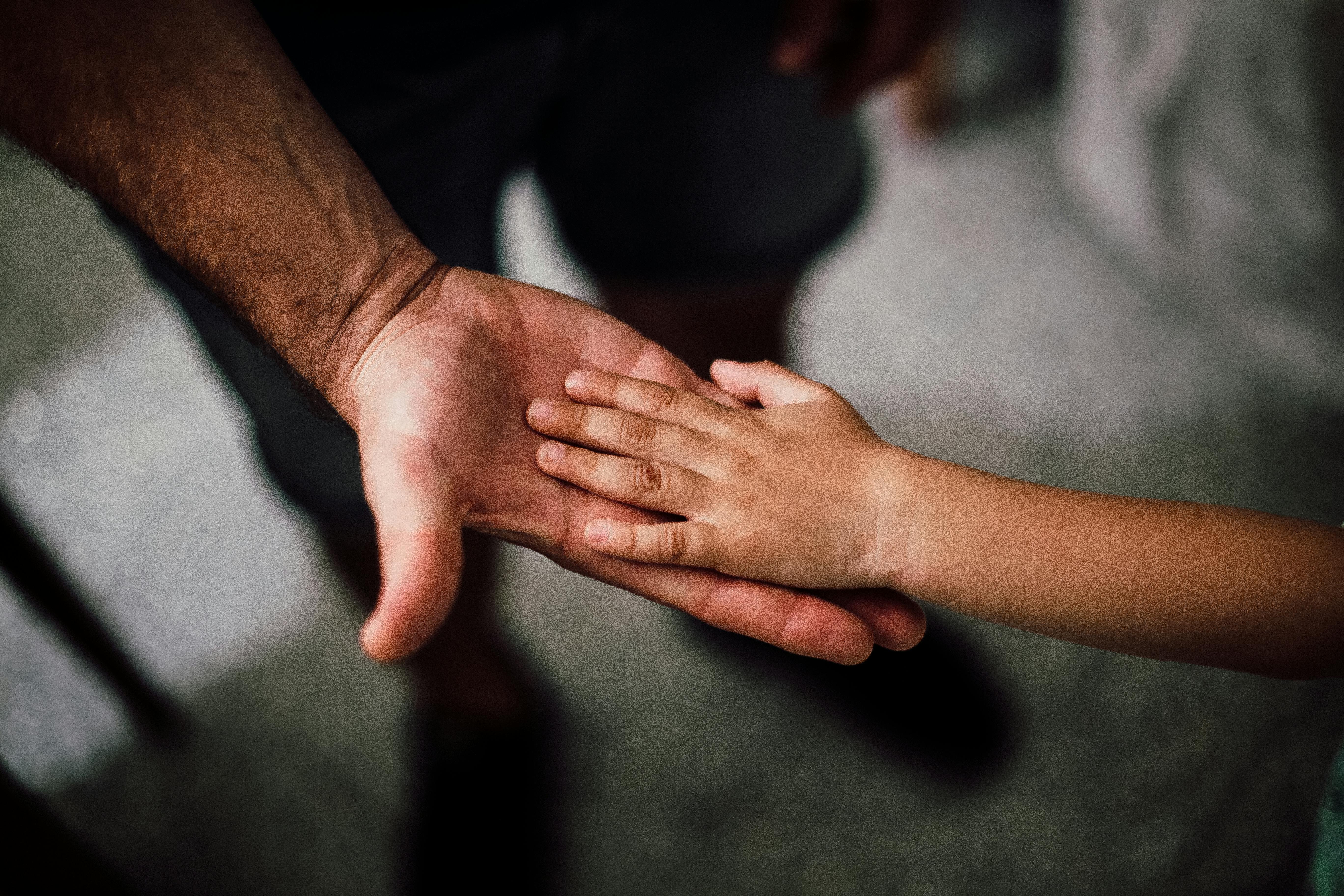 Rhode Island parent and child holding hands, illustrating emotional and legal aspects of child arrears